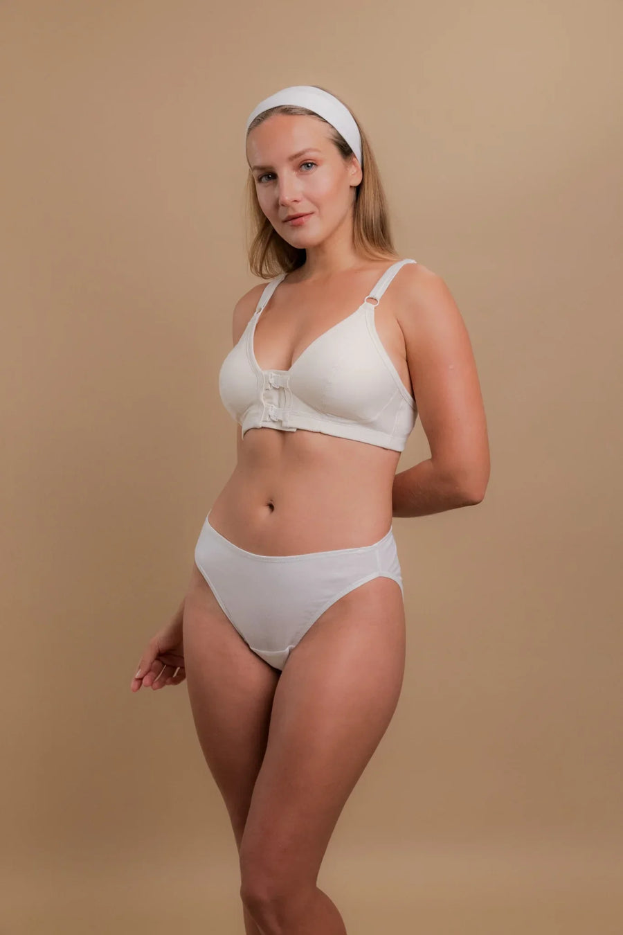 Woman wearing white organic cotton front-closure bra and briefs for sensitive skin