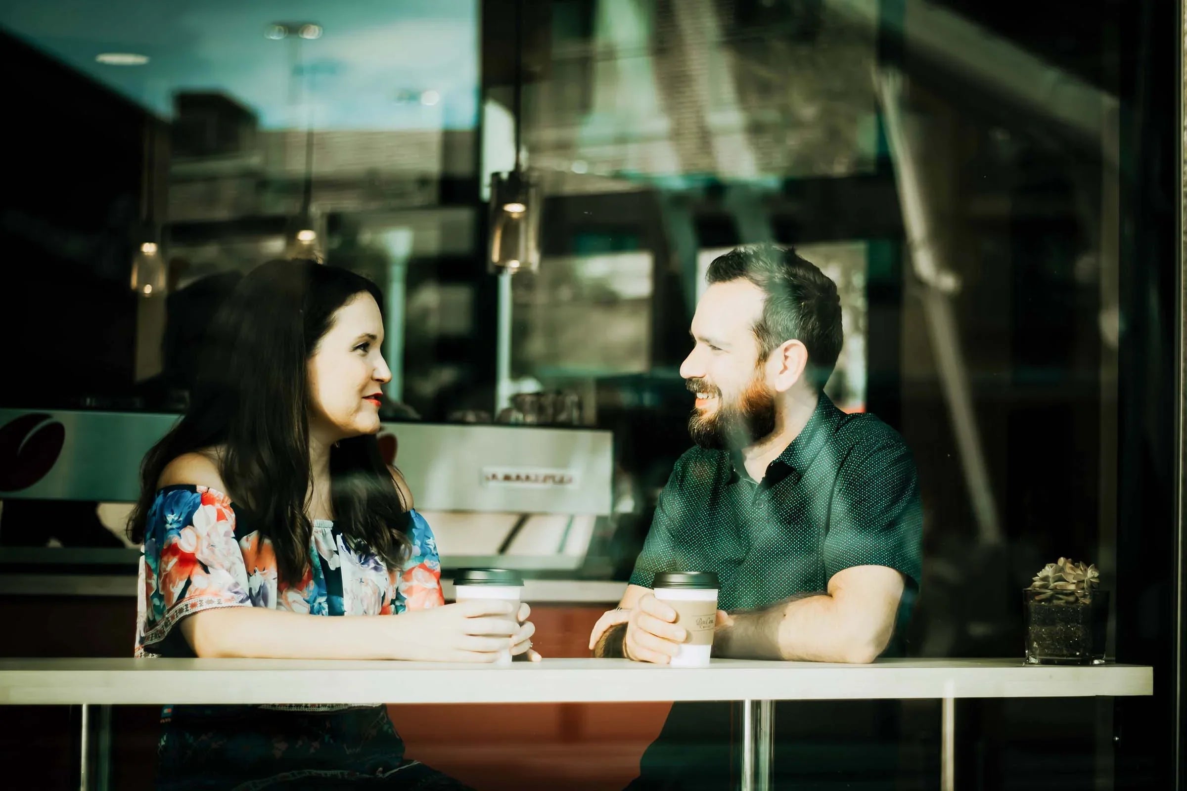 Man and woman in casual allergy-free apparel enjoying coffee at a cafe table