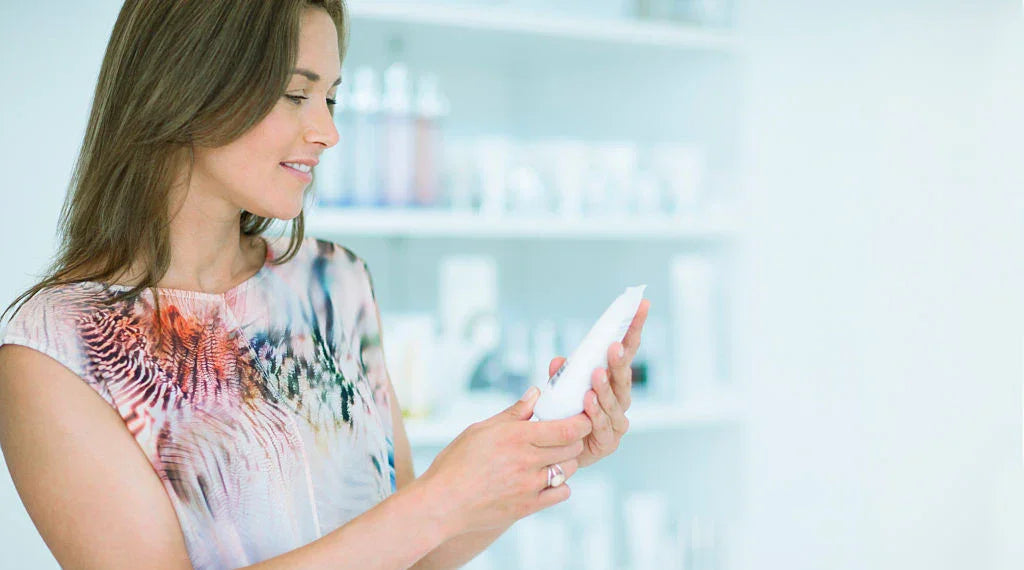 Woman examining skincare product in bright hypoallergenic apparel store
