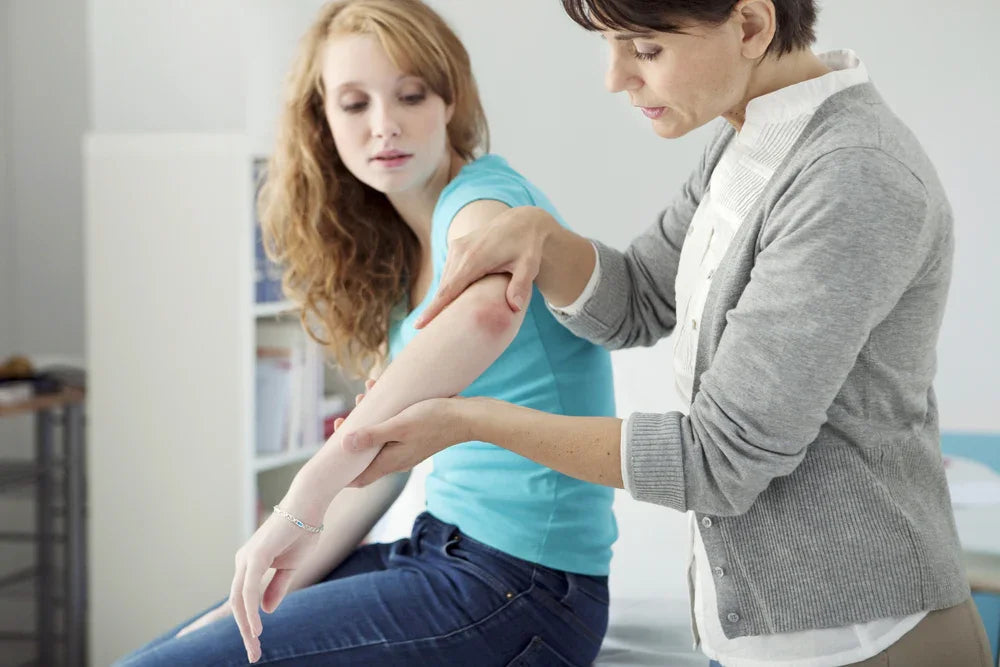 Doctor examining a woman's red irritated skin on her arm, eczema and sensitive skin care