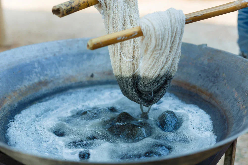 Organic cotton yarn being hand-dyed in a natural dye bath for allergy-free clothing.