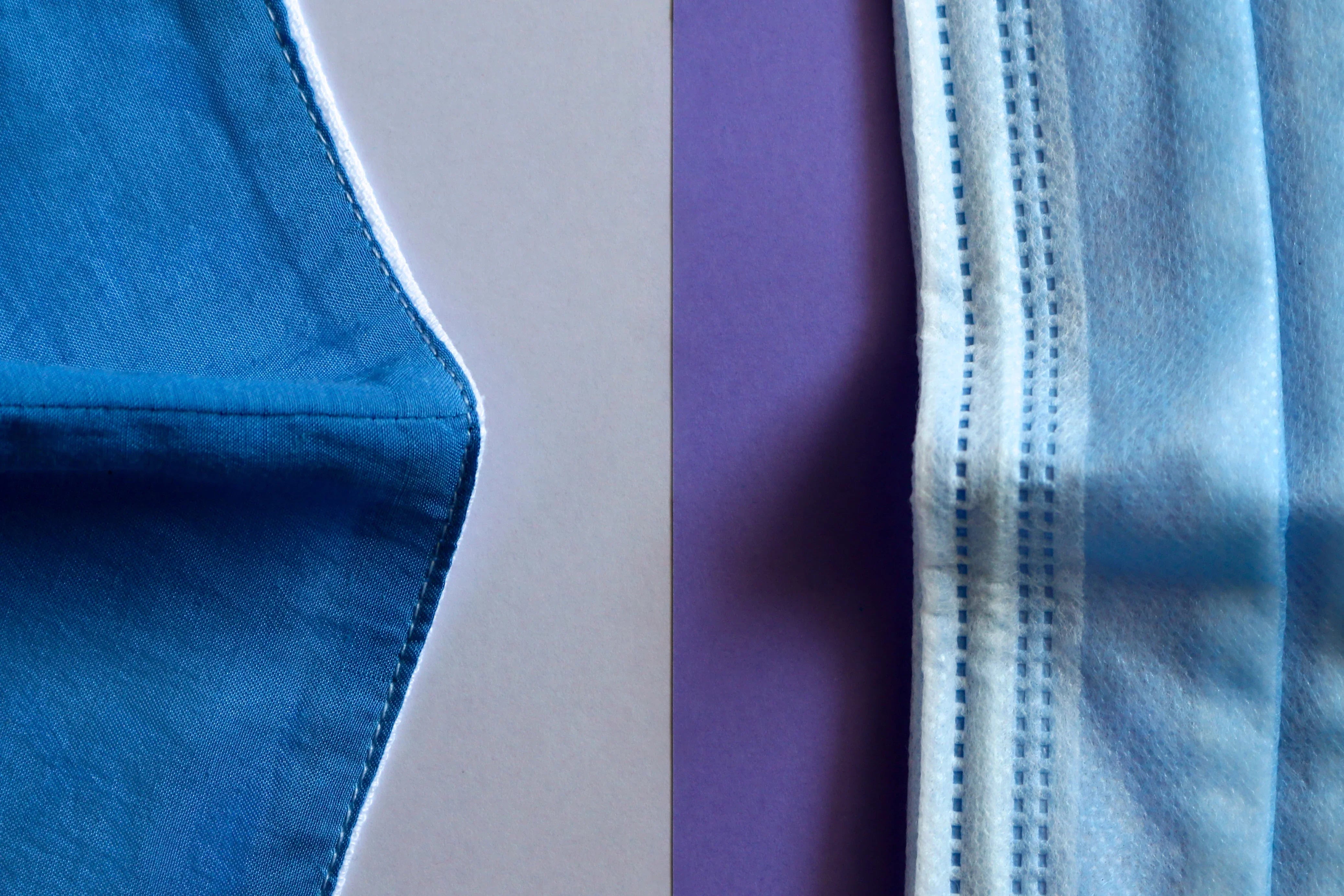 Close-up of a blue cotton face mask next to a blue disposable mask, highlighting hypoallergenic, allergy-free fabric from Cottonique.