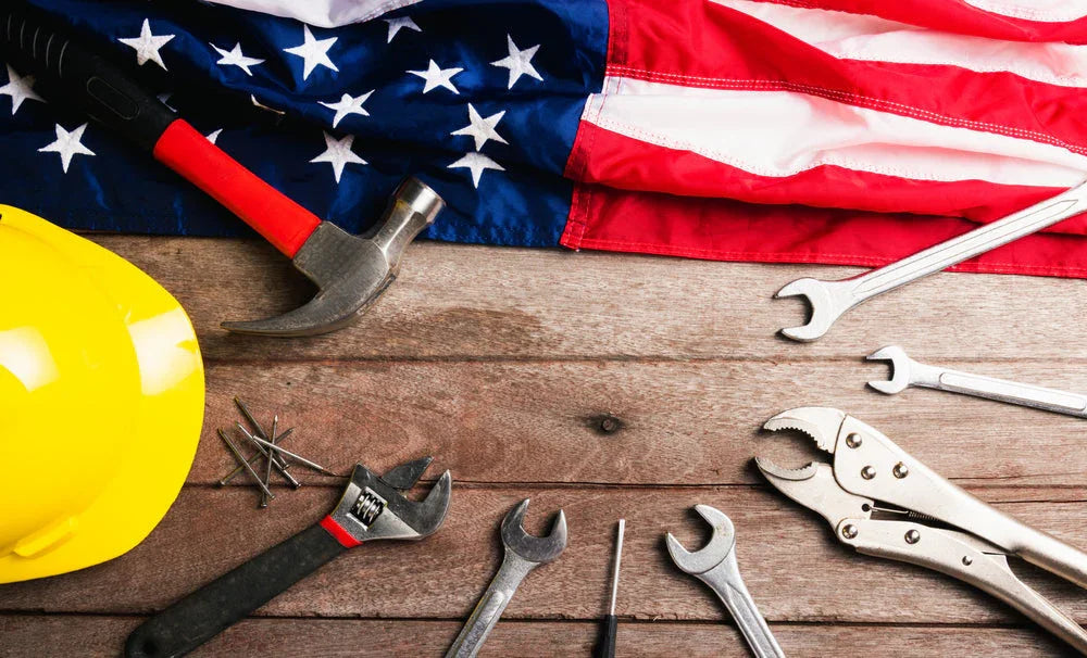 American flag, yellow hard hat, and hand tools on wooden surface, Labor Day theme