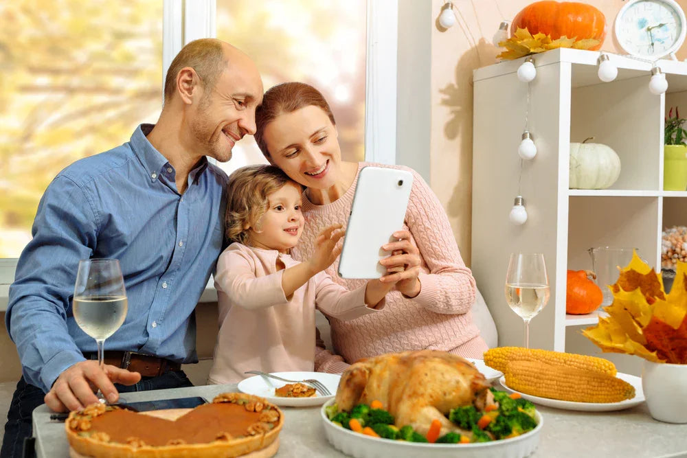 Family in autumn-themed kitchen enjoying Thanksgiving meal with turkey, pumpkin decor, and corn.