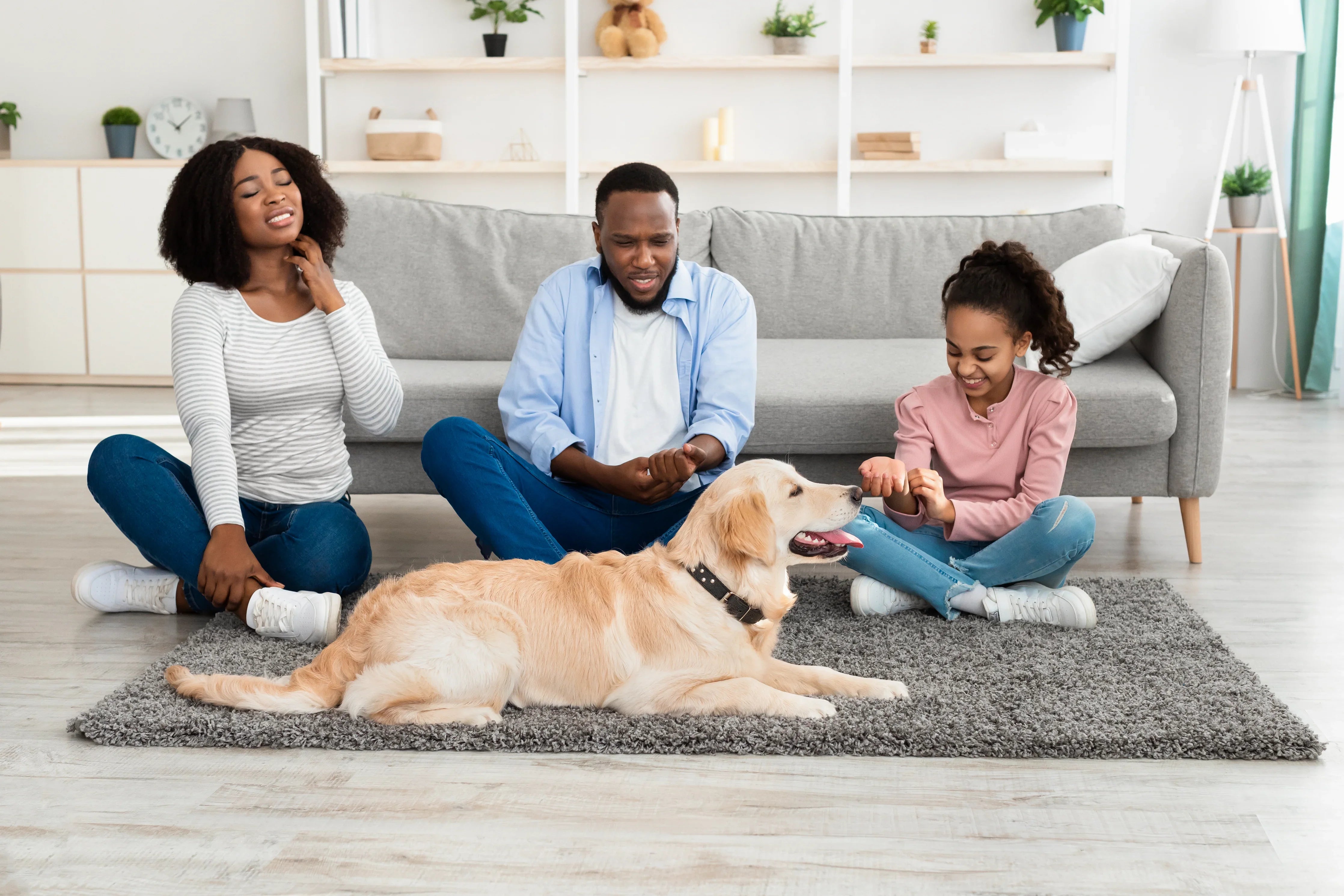 Family in allergy-free clothing with dog on living room rug, Cottonique hypoallergenic apparel