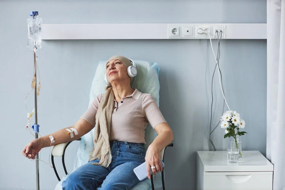 Woman in soft cotton top receiving infusion therapy, relaxing with headphones in clinic setting