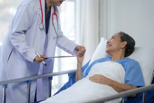 Doctor comforting patient in hospital bed, wearing hypoallergenic hospital gown
