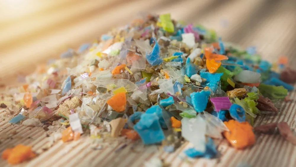 Pile of colorful microplastic fragments on fabric surface, highlighting textile pollution