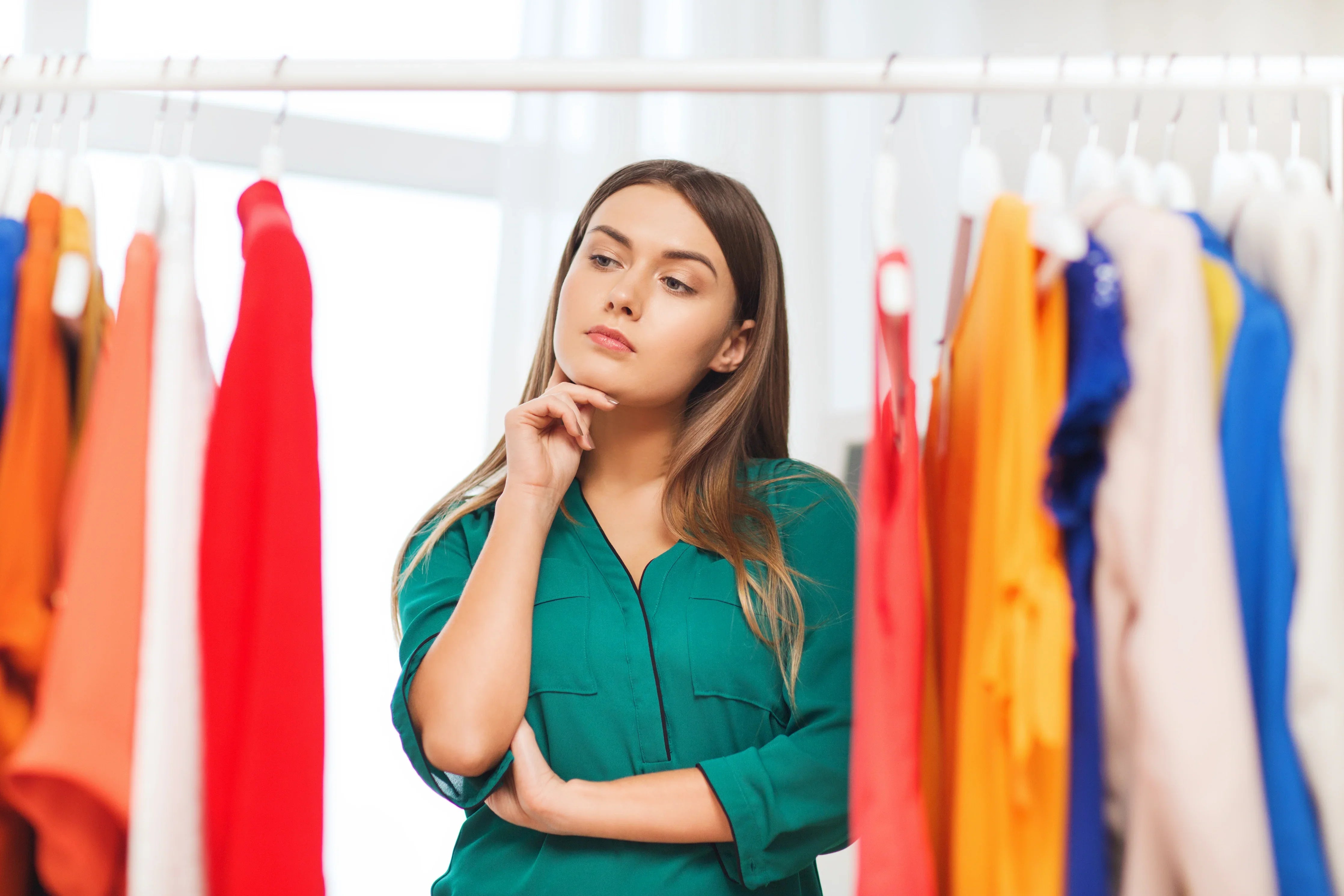 Woman choosing allergy-free cotton clothing from colorful rack, Cottonique hypoallergenic apparel