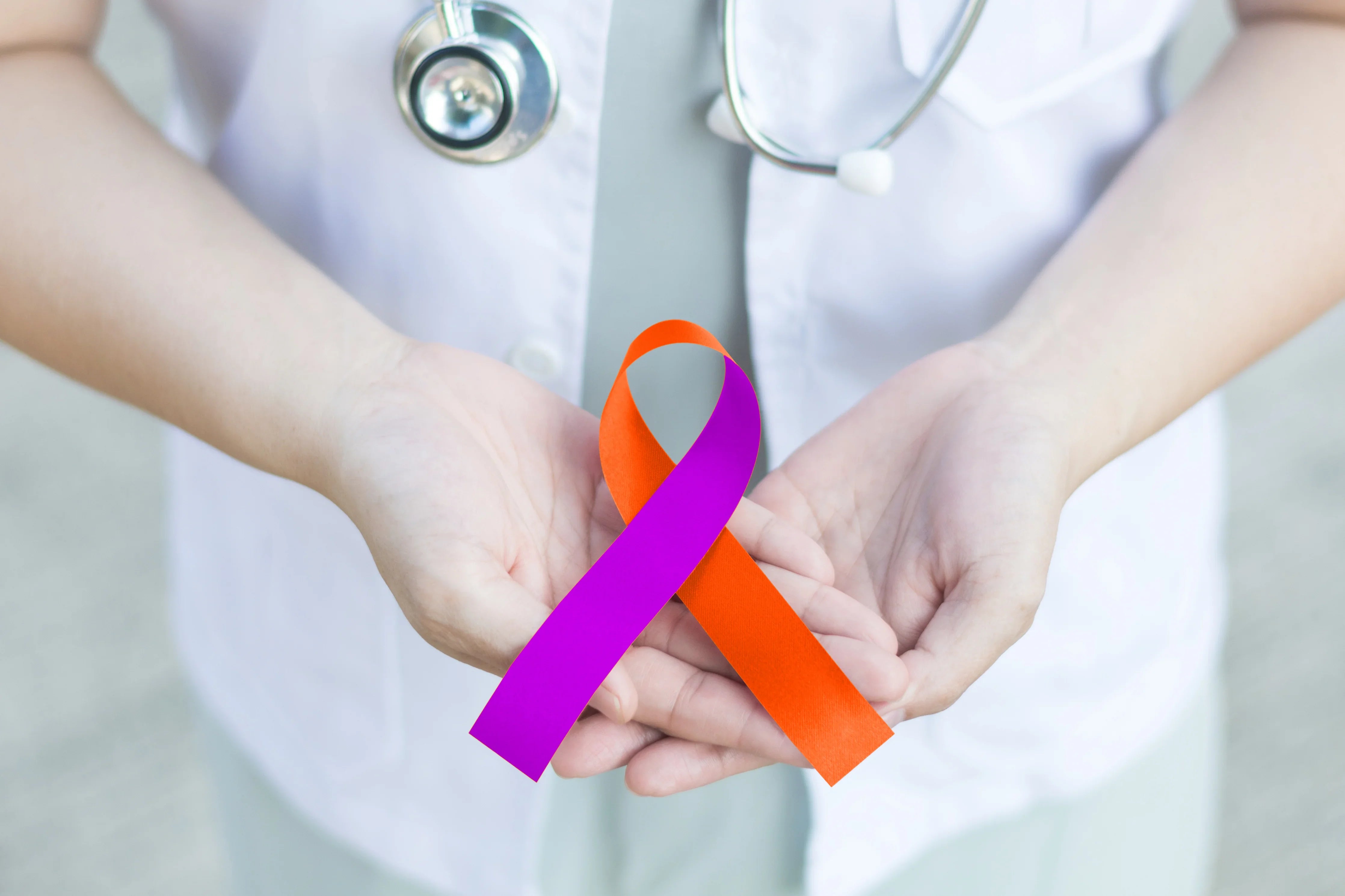 Doctor holding purple and orange awareness ribbon, symbolizing allergy and health care support