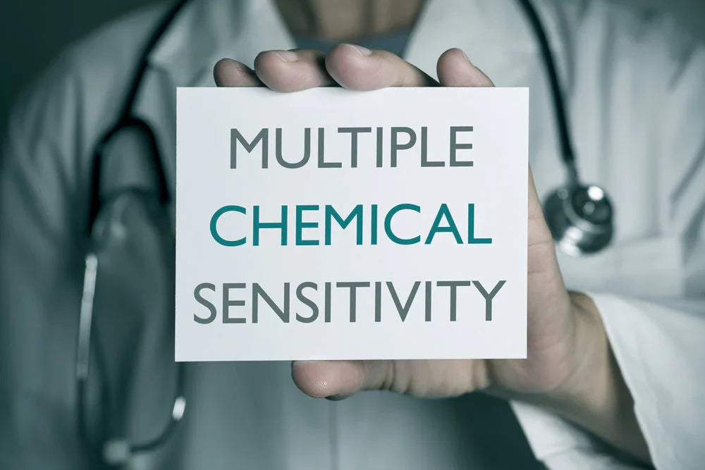 Doctor holding sign reading 'Multiple Chemical Sensitivity' for allergy awareness