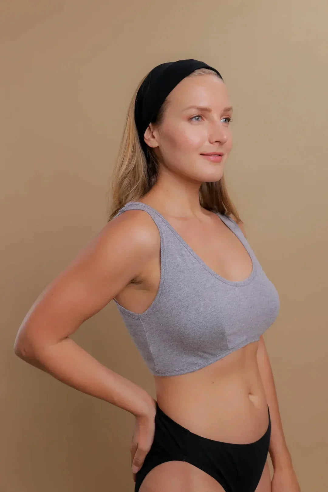 Woman wearing a gray organic cotton bralette and black underwear for sensitive skin