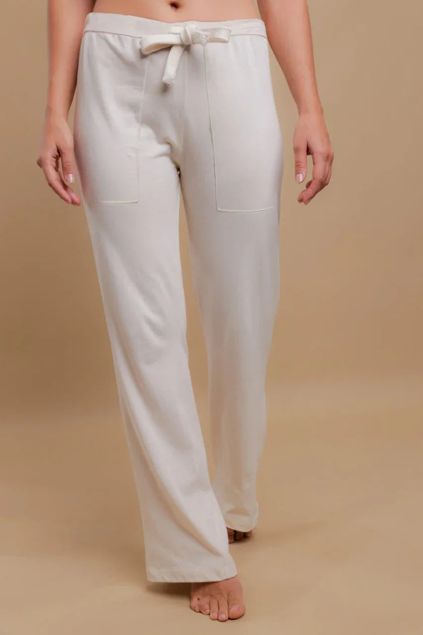 Woman wearing off-white organic cotton lounge pants with drawstring waist and front pockets