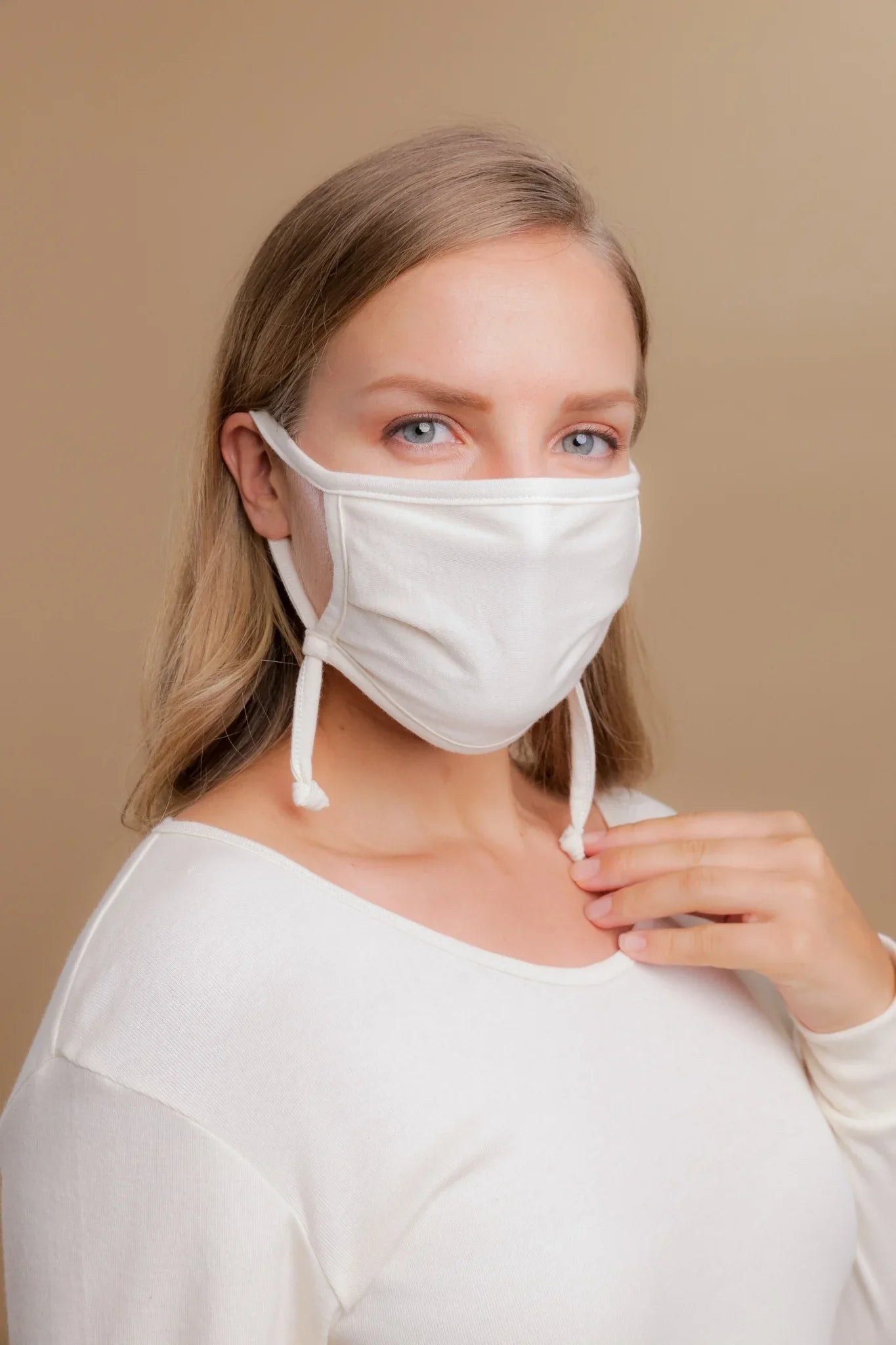 Woman wearing hypoallergenic white cotton face mask and cotton top from Cottonique