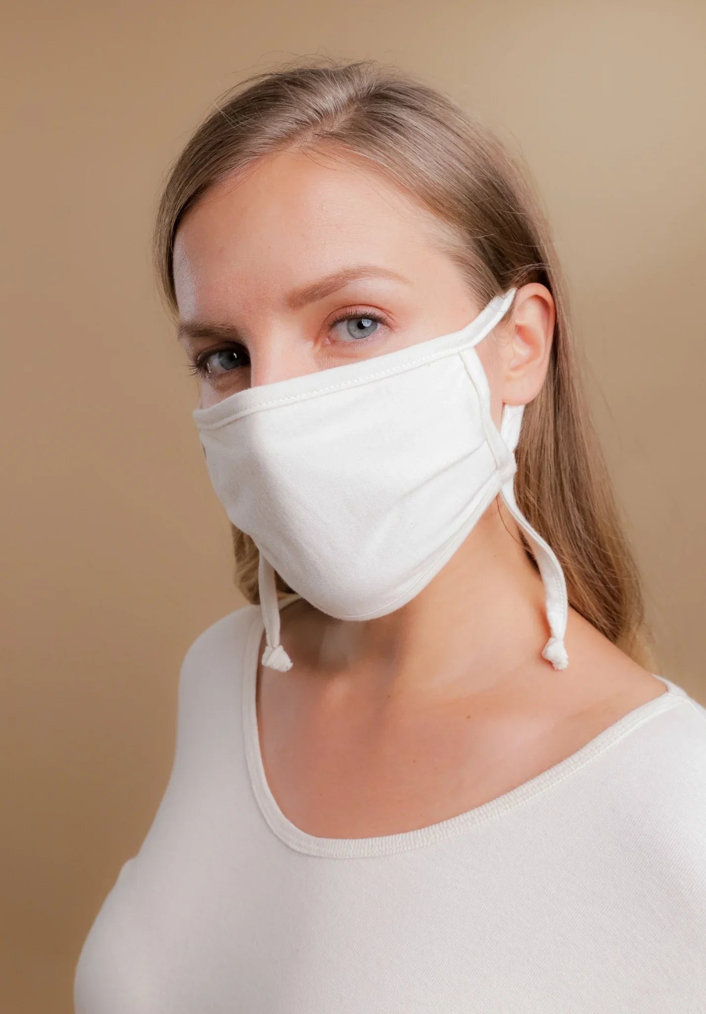 Woman wearing hypoallergenic white cotton face mask and shirt from Cottonique